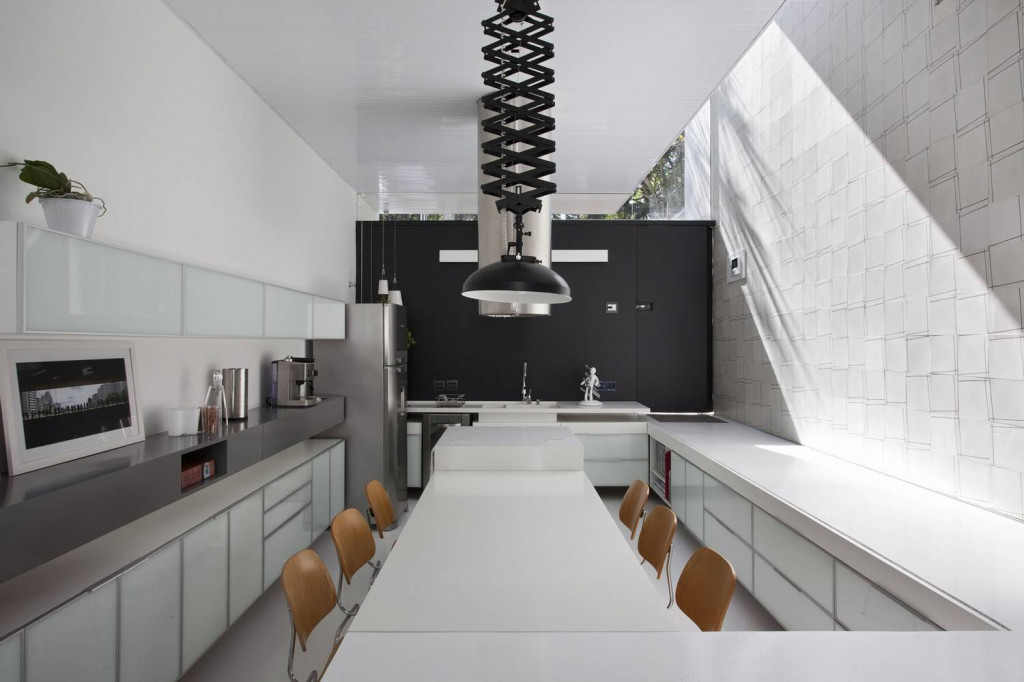Nội thất phòng bếp chạy dọc theo chiều dài căn nhà, với màu sắc chủ đạo là đen và trắng cho cảm giác về một bầu không khí trong lành, thoáng đãng và sạch sẽ